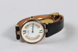 A LADIES CARTIER GILT WRISTWATCH with leather strap.