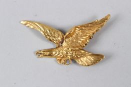 A YELLOW METAL BROOCH, modelled as an eagle with outswept wings. 55mm wide.