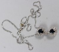 A WHITE METAL, DIAMOND AND SAPPHIRE DOUBLE CLUSTER PENDANT AND CHAIN, the chain stamped 750. 40cms