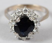 A WHITE METAL, DIAMOND AND SAPPHIRE CLUSTER RING.
