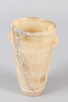 AN EGYPTIAN ALABASTER VESSEL, of tapering cylindrical form, with small lug handles. 14cms high.
