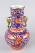 A CHINESE PORCELAIN VASE, decorated in the Imari palette, with elephant head handles. 24cms high.