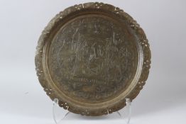 AN ENGRAVED INDIAN SIKH BRASS TRAY depicting Ranjit Singh. 36cms diameter