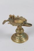 AN ANTIQUE ISLAMIC BRONZE OIL LAMP with a bird. 8cms high.