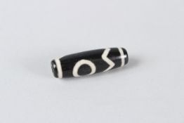 A TIBETAN HARDSTONE ZI BEAD. 3.5cms long.