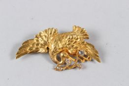 A YELLOW METAL AND DIAMOND BROOCH, modelled as a bird in flight, holding a branch in it's mouth, set