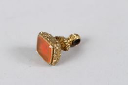 A YELLOW METAL FOB SEAL.