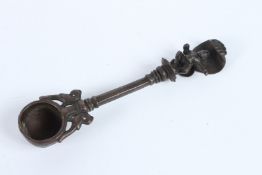 AN 18TH CENTURY MUGHAL INDIAN BRONZE OIL SPOON with Krishna finial. 17cms long