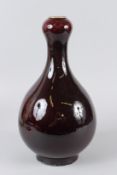 A CHINESE SANG DE BOEUF BOTTLE VASE. 36.5cms high.