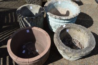 Four reconstituted stone garden pots.