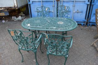 A green painted aluminium oval shaped garden table and four armchairs.
