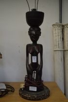 An African carved wood figural lamp.