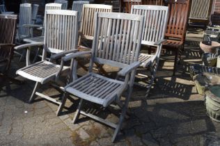 A set of four folding hardwood garden armchairs.