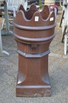 A salt glazed terracotta chimney pot with castellated rim.