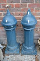 A pair of painted reconstituted stone bollards.