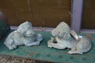 A pair of reconstituted garden ornaments modelled as recumbent dogs.