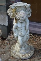 A reconstituted stone figural bird bath base.