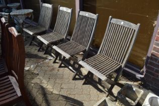 A set of four folding hardwood garden chairs.