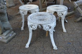 A set of three white painted cast aluminium garden tables.