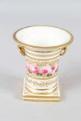 An early 19th century Coalport vase with bird head handles painted with roses and eleven gilt