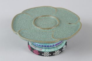 A CHINESE CELADON PORCELAIN TRAY ON STAND. 6.5ins diameter.