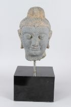 A CARVED STONE HEAD OF BUDDHA from the GANDHARA REGION. 20cms high, on a marble base.