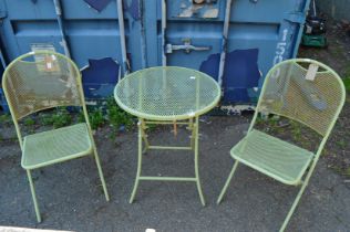 A green painted metal bistro style folding table and pair of matching chairs.