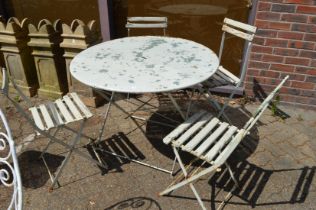 A folding circular metal garden table with four chairs.