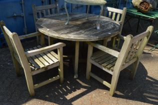 A teak circular garden table with four armchairs.