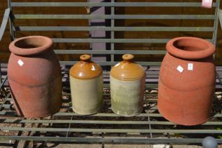 Two terracotta chimney pots and a pair of stoneware flagons.