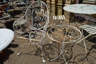 A wrought iron garden armchair and similar table.