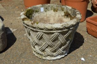 A reconstituted stone basket weave style planter.