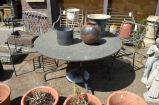 A granite circular garden table with wrought iron base together with a pair of wrought iron
