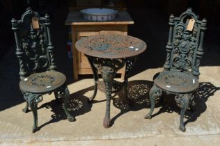 A Victorian design cast iron circular table with pair of similar chairs.