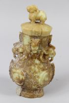 A CHINESE CARVED JADITE , TWO HANDLED VASE AND COVER with scrolls and figures. 8ins high.