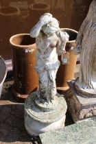 A classical concrete stone figure of a young maiden on a circular base. 3ft 8ins high.