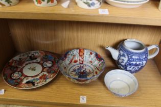 A mixed shelf of oriental pieces.