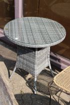 A cane circular conservatory table and a single chair.