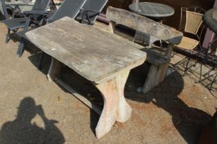 A rustic garden bench and table.