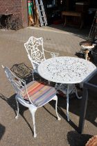 A white painted metal garden table and two chairs.