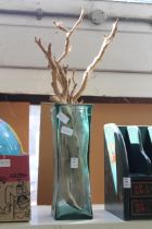A glass vase with driftwood sticks.