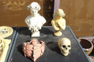 Two garden busts, a skull and a wall hanging.