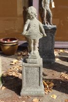A garden statue of a young girl on a plinth.