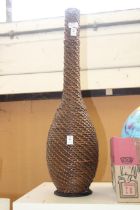 A large wicker decorative bottle.