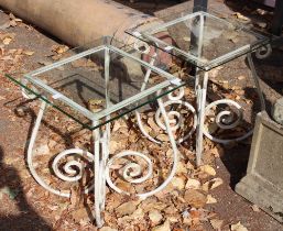 Two wrought iron tables with square glass tops.