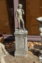 A garden statue of a man on a plinth.
