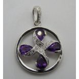 A white metal and purple stone pendant,