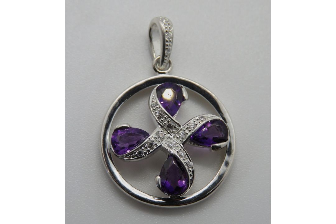 A white metal and purple stone pendant,