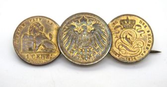 A three coin brooch