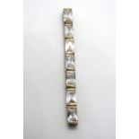 A silver pendant set with white stones,